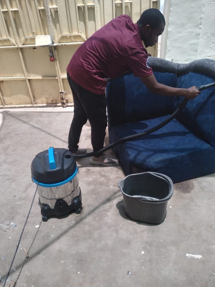 Horizon crew member vacuum-cleaning a blue sofa